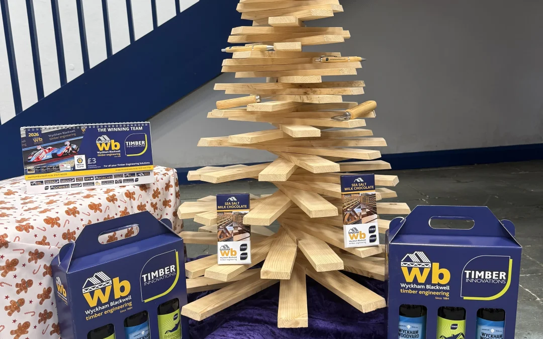 A Christmas tree made out of wood with WB and Timber Innovation beer packages below it.