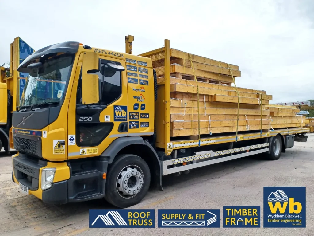 Yellow Wyckham Blackwell lorry with piles of timber on the back