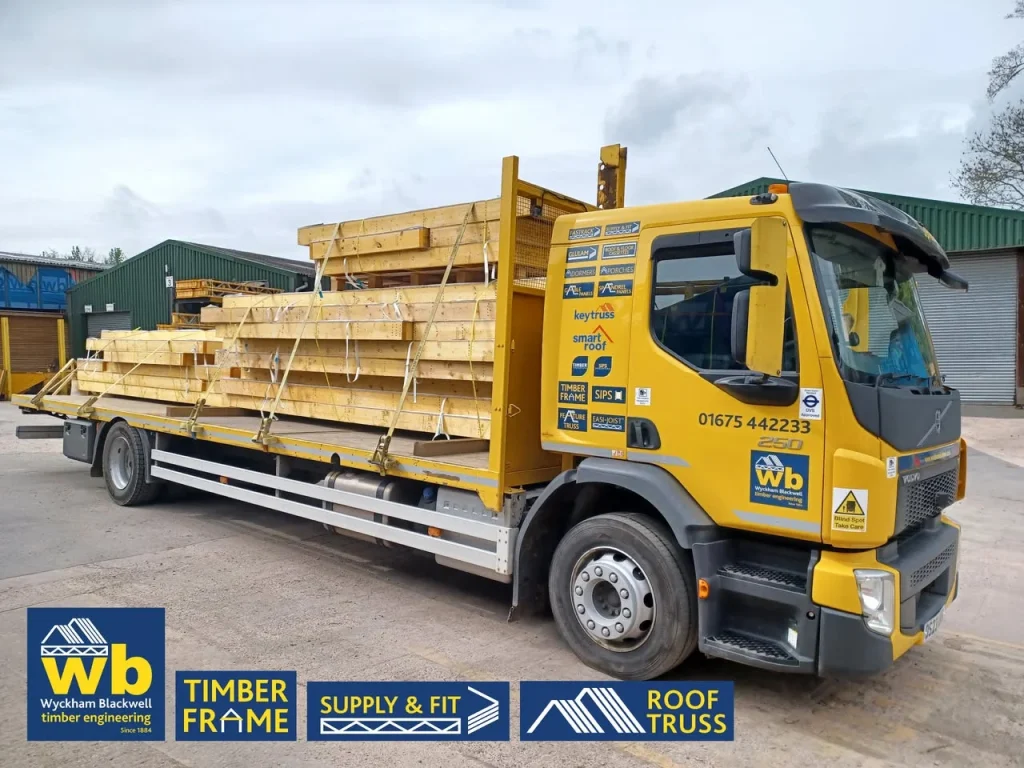 Yellow Wyckham Blackwell lorry with piles of timber on the back