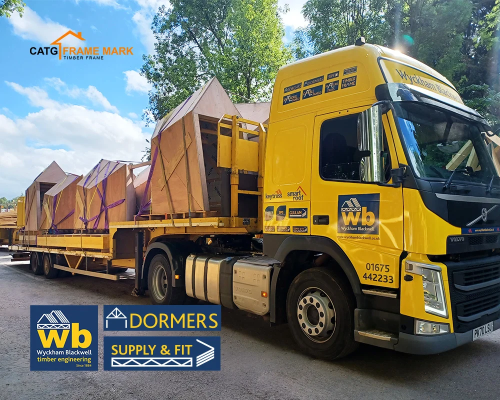 Yellow Wyckham Blackwell flatbed truck carrying pre-built timber Dormers.