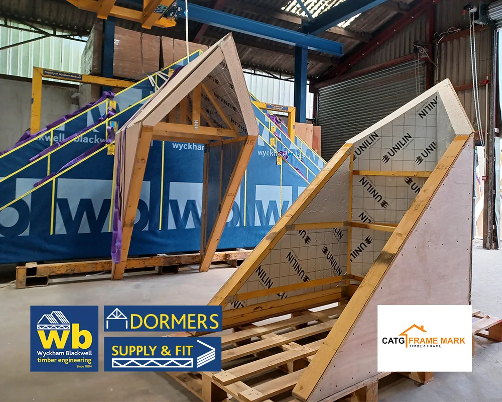 Two Wyckham Blackwell timber Dormer frames on pallets inside a workshop.