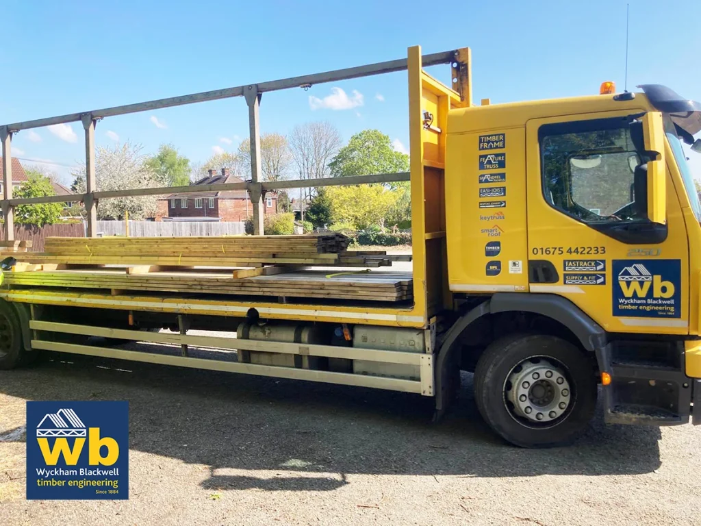 Yellow Wyckham Blackwell flat bed lorry with timber on