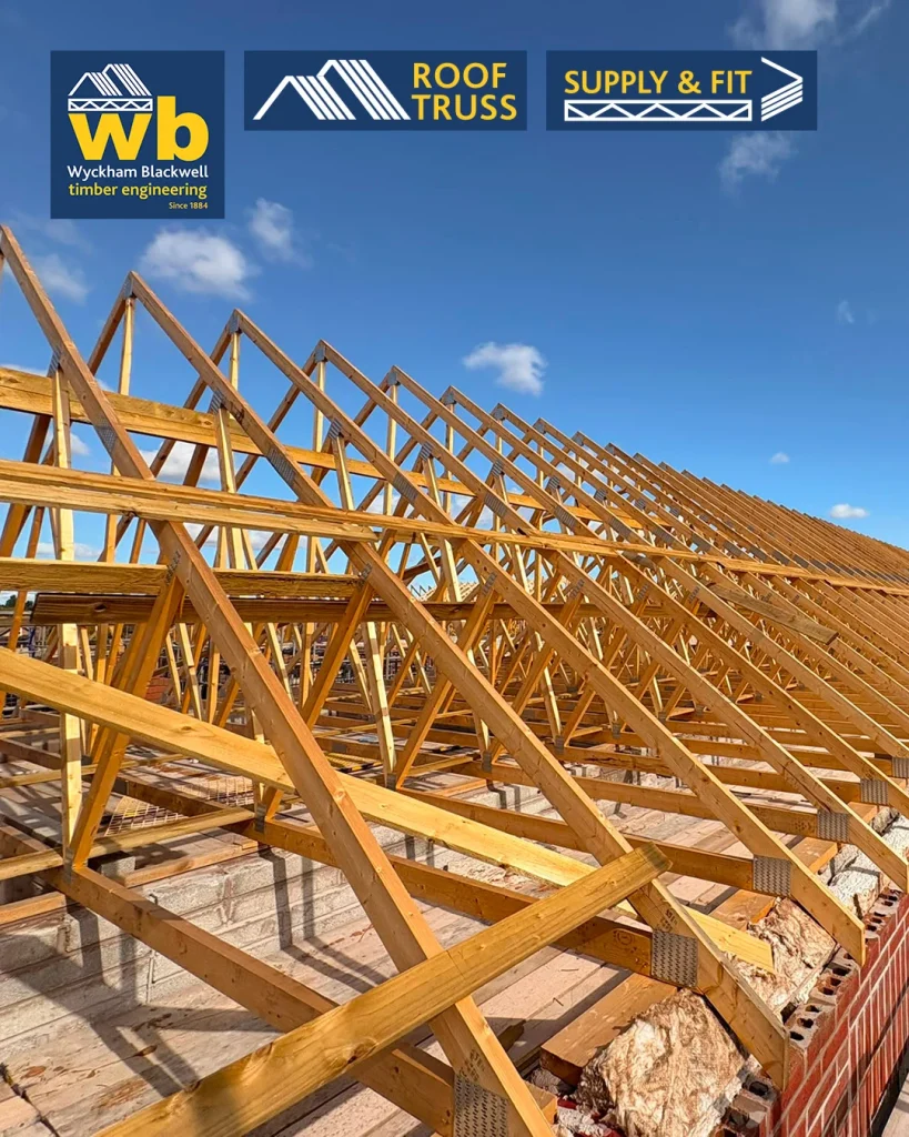 Rows of timber Roof Trusses on a building frame under a blue sky, with Wyckham Blackwell logos above.